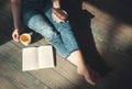 Cozy photo of young woman with tea and cake sitting on the floor