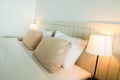 Cozy pillow and vintage bed lamp in double bedroom in luxury hotel