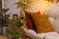 Cozy pillows on the sofa near Christmas trees in pots