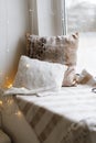 Cozy Pillows on Window Seat with Warm Lights Royalty Free Stock Photo