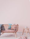 Cozy pink nursery with trendy furniture, wooden crib and table