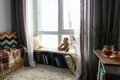 Cozy place for rest with book shelf near window in room Royalty Free Stock Photo