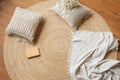 A cozy place to read on the floor. Jute woven round carpet, macramÃÂ© pillows, plaid and book