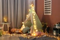 Cozy play tent for kids with glowing garland in room interior