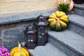 Cozy porch of the house with vintage lanterns in fall time. House entrance staircase decorated for autumn holidays, fall flowers a