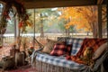 cozy porch swing with plaid blankets and fall wreath