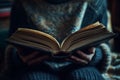 Cozy reading moment, hands holding an open book in a peaceful atmosphere Royalty Free Stock Photo