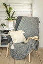 Cozy reading nook with gray chair and decorative pillow