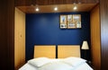 Cozy Bed Room with Blue Wall, White Covers and Wooden Closet Royalty Free Stock Photo