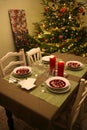 A cozy room in a country house prepared for Christmas Eve supper.