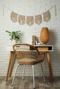 Cozy room interior with desk and stylish macrame on wall