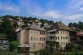 Rural houses among the trees and the river with visible minarets of the mosque. Architecture of residential buildings in Bosnia