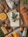 Cozy Rustic Christmas Flat Lay with Orange Slices, Wrapped Gifts, Pine Sprigs, Towels, and Holiday Scents on Wooden Table