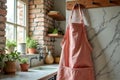 Cozy rustic kitchen with pink apron and indoor plants near bright window Royalty Free Stock Photo