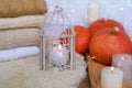 Cozy Scandinavian hyugge, three orange pumpkins, white candles, woolen clothes, sheepskin, halloween concept, cozy home,