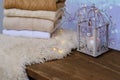 Cozy Scandinavian hyugge, white candles, woolen clothes in a pile, sheepskin, halloween concept, cozy home, aromatherapy