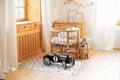 Cozy Scandinavian lights baby room: wooden crib with bedding and plush toys. Retro style child toy racing car in children room. Mo Royalty Free Stock Photo