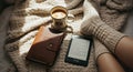 A cozy scene with coffee, journal, ereader, and knitted socks on bed Royalty Free Stock Photo