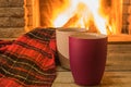 Cozy scene near fireplace with cups of hot tea and cozy warm scarf Royalty Free Stock Photo