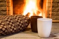 Cozy scene near fireplace with two cups of hot tea and cozy warm scarf. Royalty Free Stock Photo