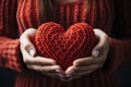 Hands of young woman in knitted sweater holding a red heart Ai generative Royalty Free Stock Photo