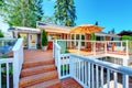 Cozy screened walkout deck with patio area and white railings staircase. Royalty Free Stock Photo