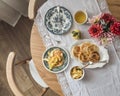 Cozy served homemade summer breakfast - pancakes with apple sauce, vintage dishes, a bouquet of dahlias on a retro tablecloth on a Royalty Free Stock Photo
