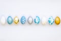 Cozy Set of 9 gold, blue and silver Easter eggs on white background. Top view Royalty Free Stock Photo