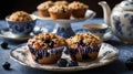 A cozy setting featuring blueberry muffins on elegant tableware with a teapot and cup Royalty Free Stock Photo