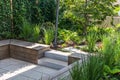 Cozy shady seating area made of concrete and wood in a garden Royalty Free Stock Photo