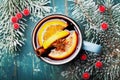 Cozy shot of christmas mulled wine or gluhwein with spices and orange slices on teal table top view. Traditional drink on winter. Royalty Free Stock Photo