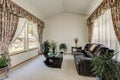 Cozy sitting area with elegant window curtains and vaulted ceiling