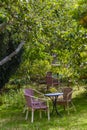 Cozy sitting areas made of wicker chairs and tables in a romantic orchard Royalty Free Stock Photo