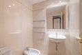 Cozy small bathroom with beige tiles on the wall, vanity and toilet and bidet with mirror on the wall. Concept of modern Royalty Free Stock Photo