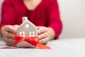 Cozy small home model with snow fall with copy space on grey background. Christmas and happy new year composition Royalty Free Stock Photo