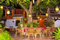 Cozy snack bar Oasis with beautiful flowers and trees lit by candle lights at calm night in Murcia, Spain