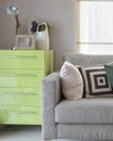 Cozy sofa with geometric pattern pillows and green sideboard in Royalty Free Stock Photo