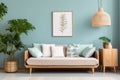 Cozy sofa with mint and white pillows, potted houseplant and wooden cabinet near blue wall with poster and pendant light