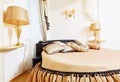 Cozy soft beautiful round bed in classical golden bedroom Royalty Free Stock Photo