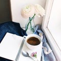 Cozy spring still life. Mug of hot coffee, opened empty notebook with warm plaid on vintage windowsill. Feminine styled