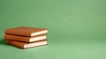 A cozy stack of brown hardbacks sits elegantly on a soft green backdrop, perfect for book lovers and aesthetic enthusiasts Royalty Free Stock Photo