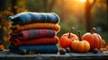 Cozy stack of knitted sweaters and pumpkins in warm autumn sunlight outdoors Royalty Free Stock Photo
