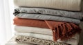 Cozy Stack of Textured Blankets and Throws in Earthy Tones Royalty Free Stock Photo