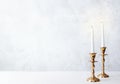 Cozy still life with burning candles in golden candlesticks on pastel light background. Concept Christmas Advent Royalty Free Stock Photo