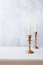 Cozy still life with burning candles in golden candlesticks on pastel light background. Concept Christmas Advent Royalty Free Stock Photo