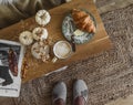 Cozy still life - cappuccino, croissant, magazine, autumn decor on a wooden bench, top view. Scandinavian style interior