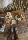 Cozy still life - cappuccino, croissant, magazine, autumn decor on a wooden bench, top view. Scandinavian style interior