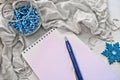 Cozy still life in grunge style monochrome shades and blue color, notepad, pen and Christmas decorations and warm plaid Royalty Free Stock Photo