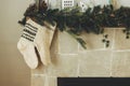 Cozy stockings hanging on mantel in modern farmhouse living room. Rustic christmas fireplace with warm knitted stockings and Royalty Free Stock Photo