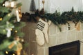 Cozy stockings hanging on mantel in modern farmhouse living room. Rustic christmas fireplace with warm knitted stockings and Royalty Free Stock Photo